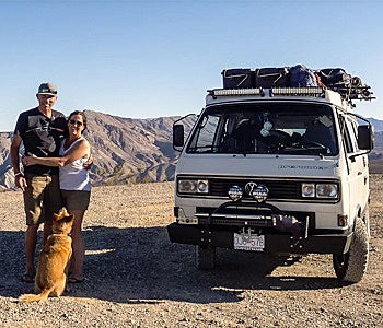 Pictured: a couple poses with their dog beside a parked white van