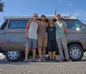Pictured: four people stand in front of a VW vanagon