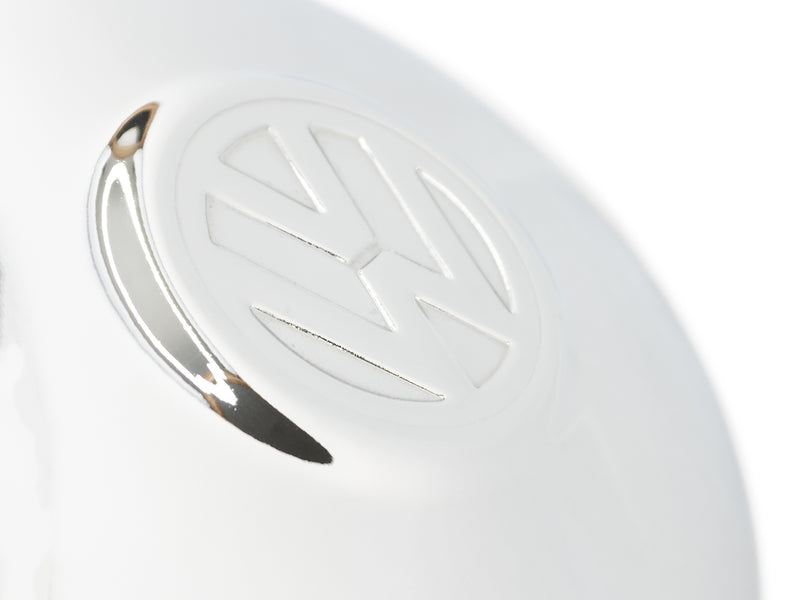 Close up of volkswagen logo on chrome hubcap on white background 